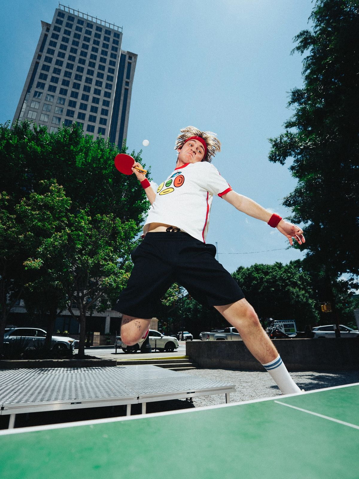 Player mid-air making a table tennis shot with city skyline